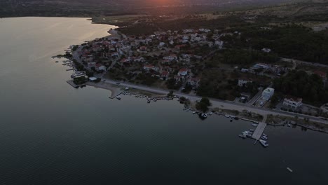 Drone-Sunrise-Over-Greek-Coastal-Village:-Mountains-and-Boats-in-Morning-Glow