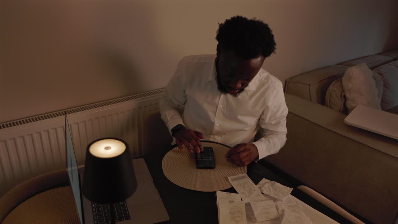 Black Male Sorting Out Finances In Living Room in Home
