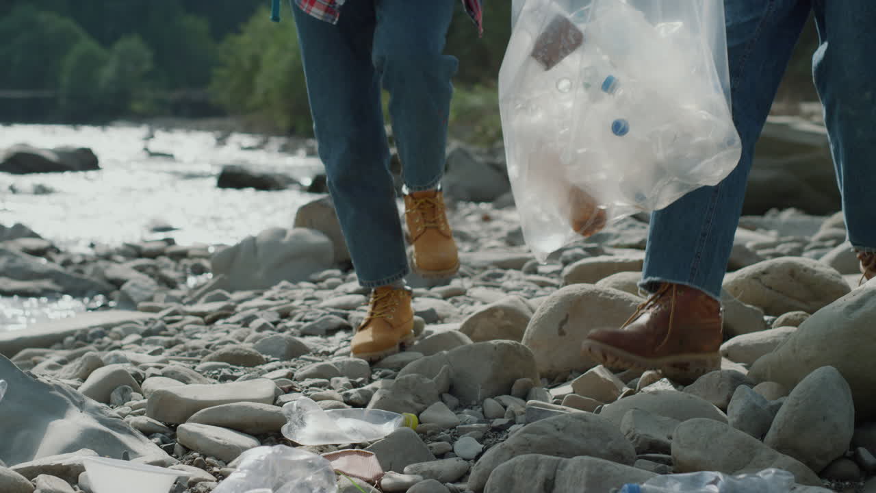 mujer y hombre recogiendo botellas en el río. voluntarios recolectando residuos para reciclar.