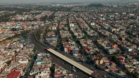 overhead view of mexican suburban area with multi-lane road intersection and moving traffic