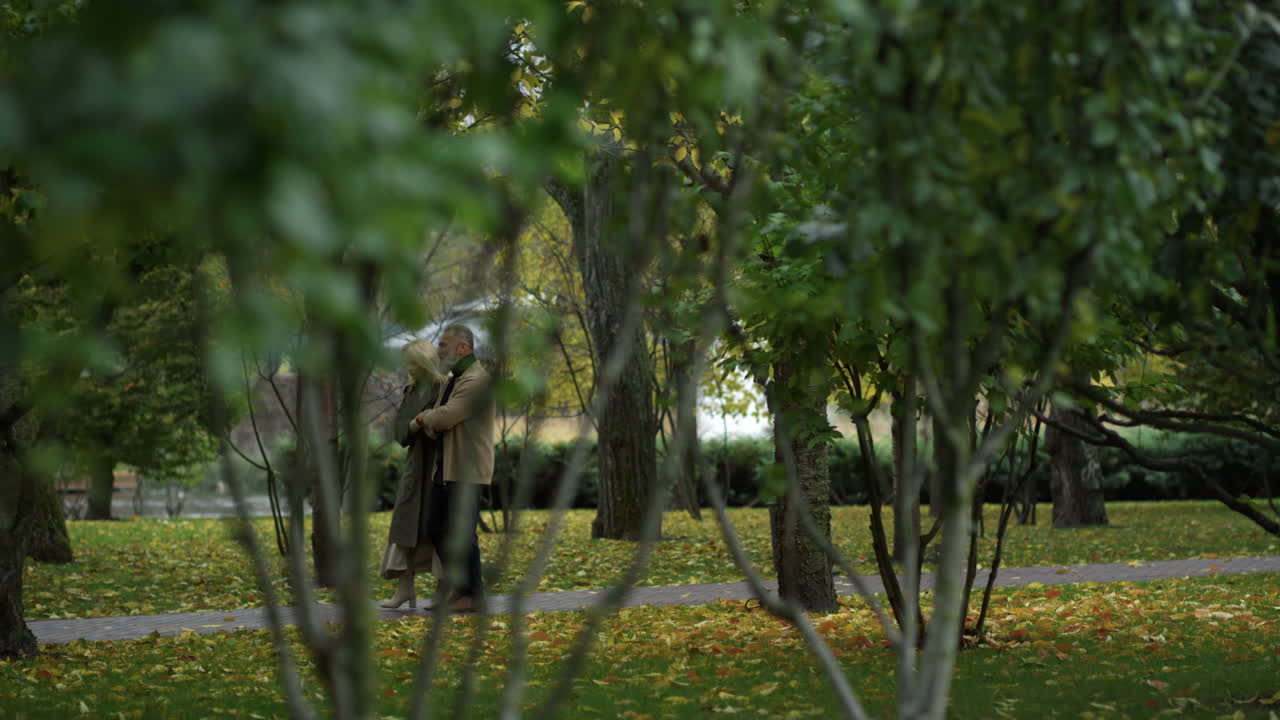 tomada panorámica de una pareja madura con estilo caminando en la naturaleza de otoño.