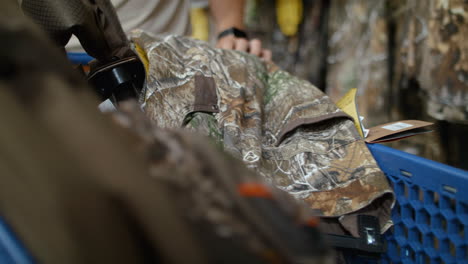 man putting hunting clothes in his cart at a retail store