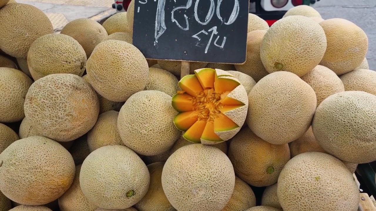 Close-up of neatly presented honey melons for sale at a local street market in Santiago de Chile, showcasing fresh produce and vibrant colors in an urban food market