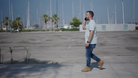 man walking and talking on phone in a city parking lot