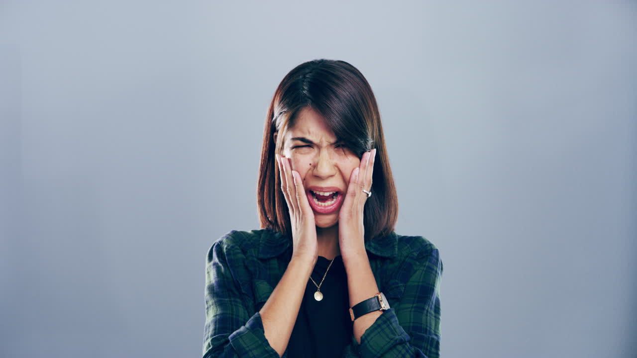 회색 배경 에 비춰 울고 있는 젊은 여자