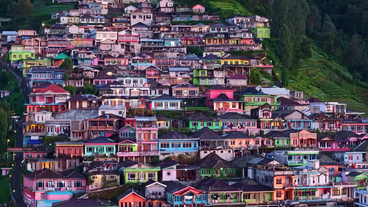 Vista aerea all'alba del villaggio di Nepal van Java sul pendio, con edifici e tetti colorati, in un paesaggio rurale indonesiano.