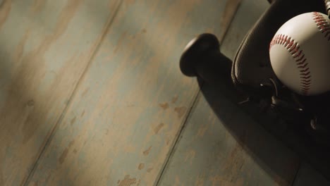 close up studio baseball still life with bat ball and catchers mitt on aged wooden floor 3