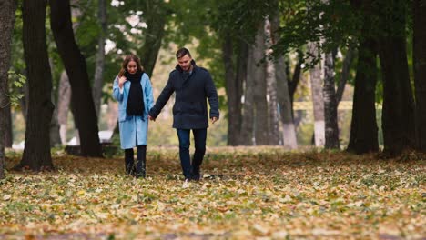 a young couple strolling through the autumn park