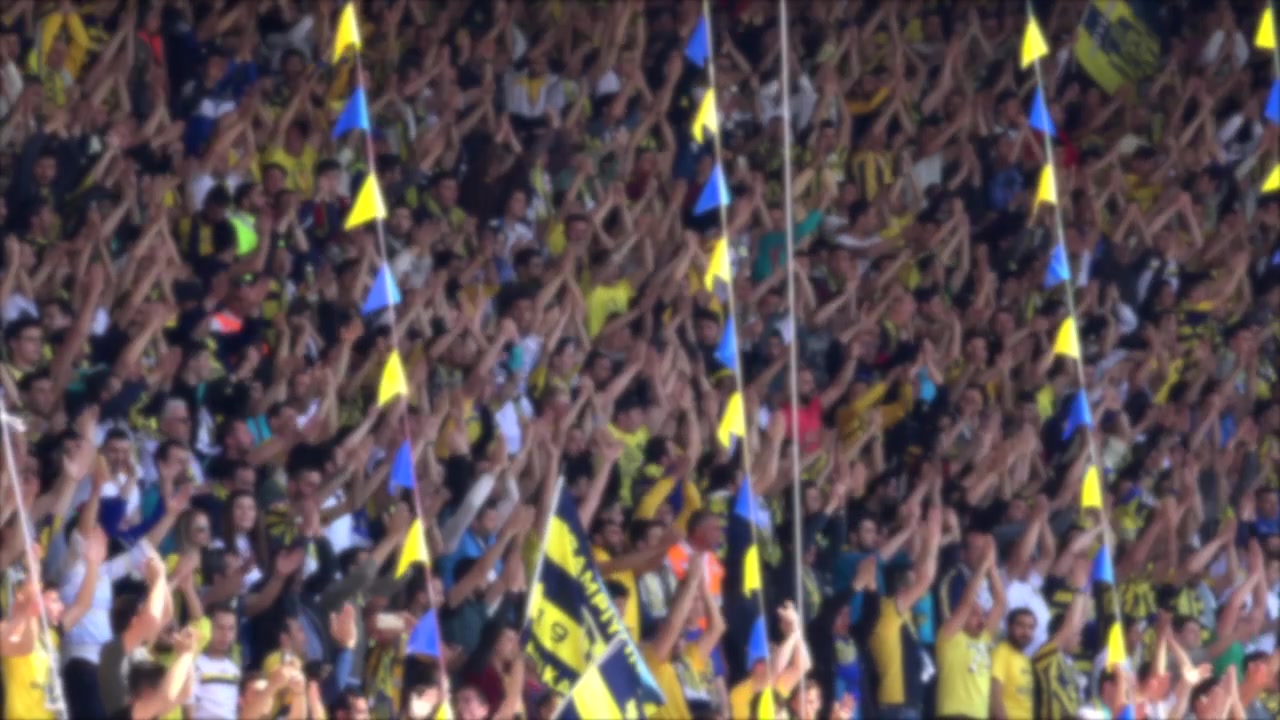 Passionerede fodboldfans hepper og klapper på stadion
