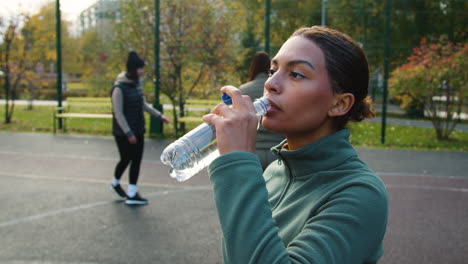 Woman drinking water outdoors