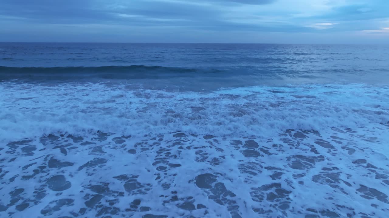 스페인 메노르카의 파란 파도, 바다 위를 가까이 날아다니는 항공 드론