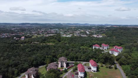 Drone-shot-flying-pass-buildings-while-panning-right-over-low-rise-buildings-during-mid-afternoon