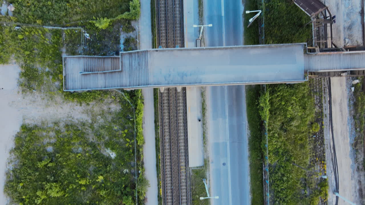 Aerial shot over no traffic street in the city, railroad tracks near the street