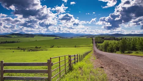 el lapso de tiempo de una hermosa tarde de verano muestra la típica acumulación de nubes convectivas de la tarde a lo largo de una carretera rural cercana a la región de las montañas rocosas del sur de alberta.