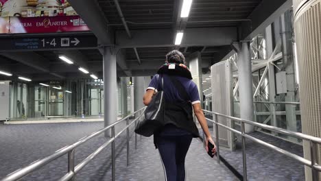 person walking through suvarnabhumi airport corridor