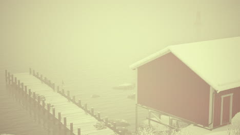 red cabin by the sea in foggy winter weather