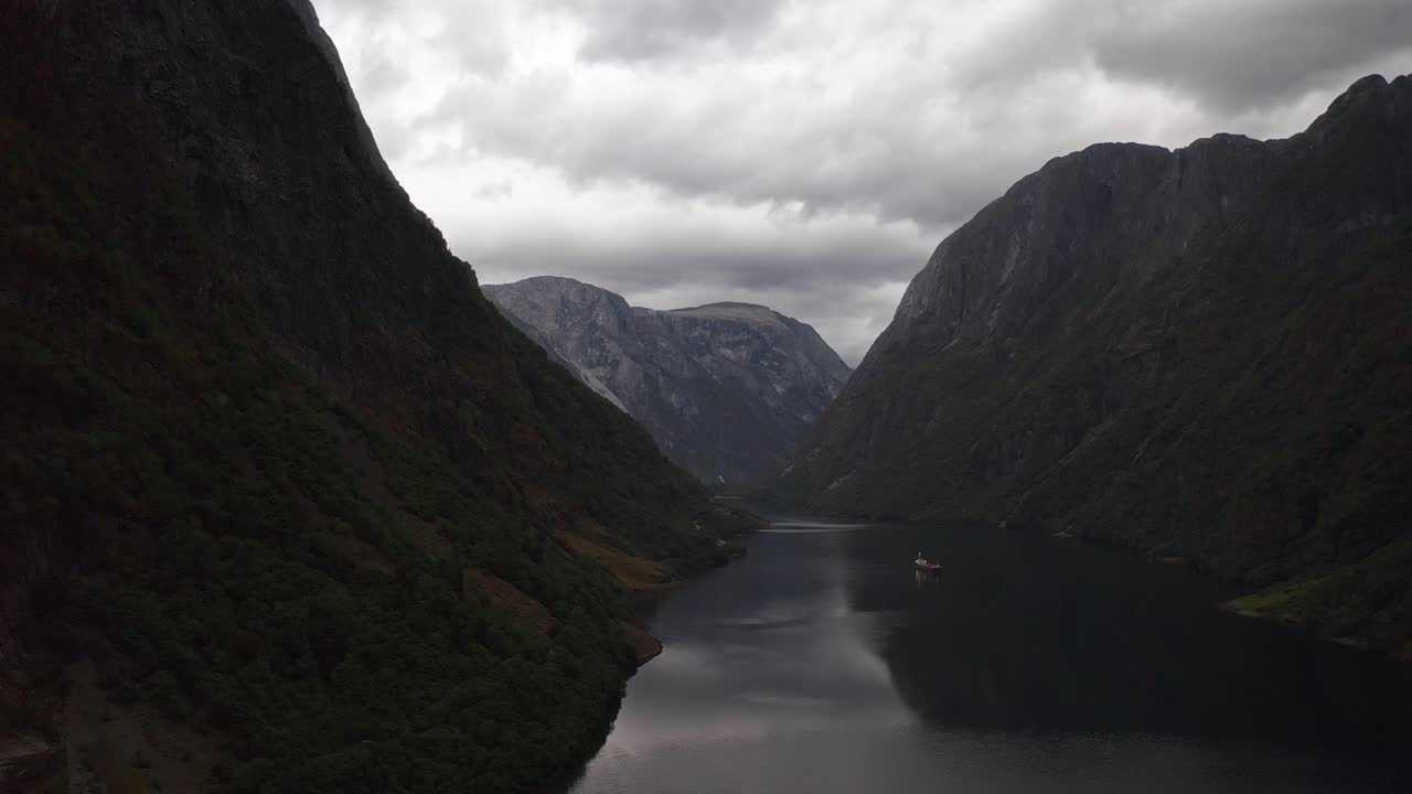 Vista serena di un fiordo norvegese, circondato da imponenti montagne e cieli nuvolosi