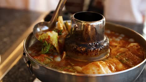 ladle serving soup from a hot pot