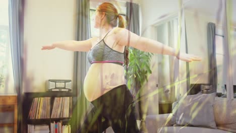 animation of grass over caucasian pregnant woman exercising at home