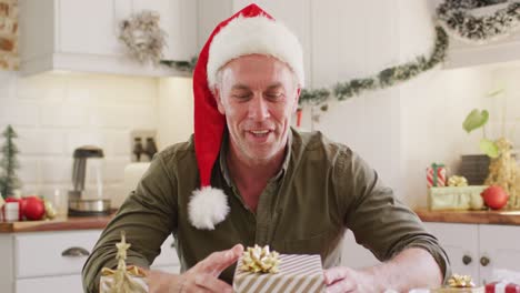 happy caucasian man wearing santa claus hat, having video call