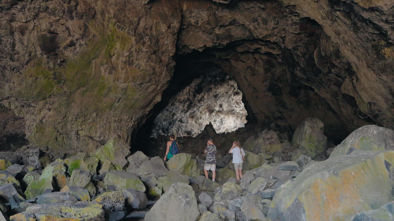 People exploring a large rocky cave
