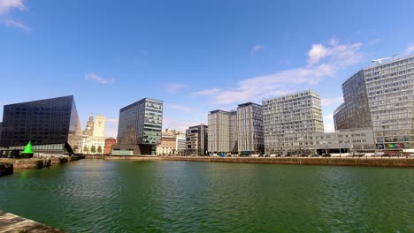 time lapse clouds passing over modern contemporary urban city business buildings waterfront skyline