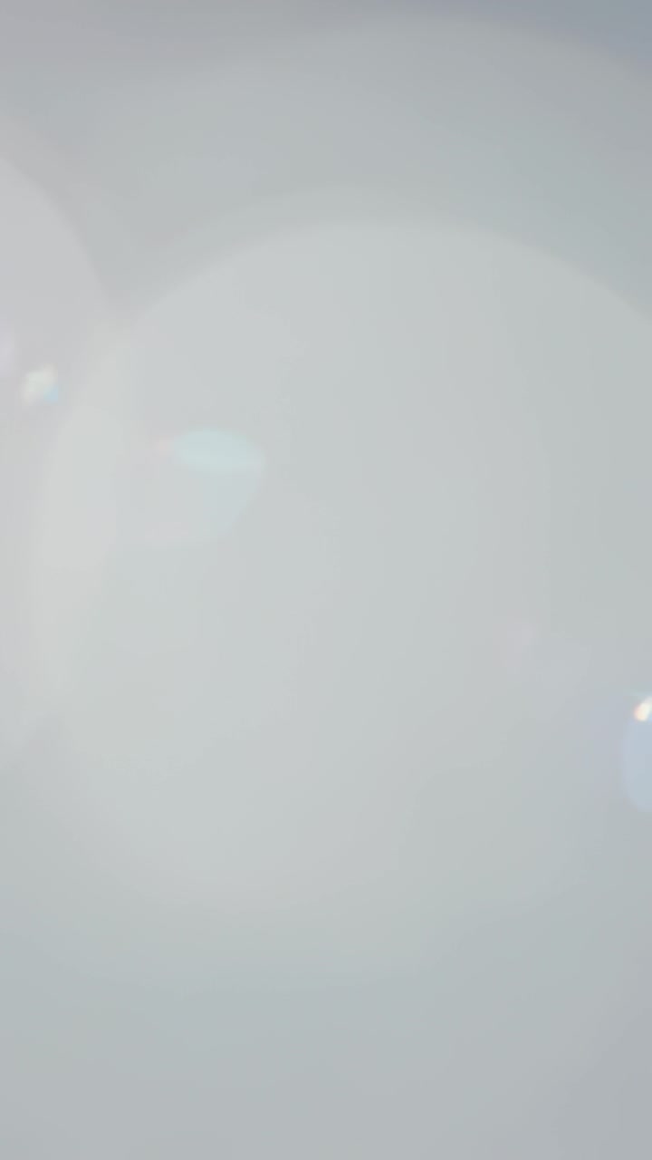 Vertical video: Starting left overlap, center flare growing on grey with lower-right spot for study