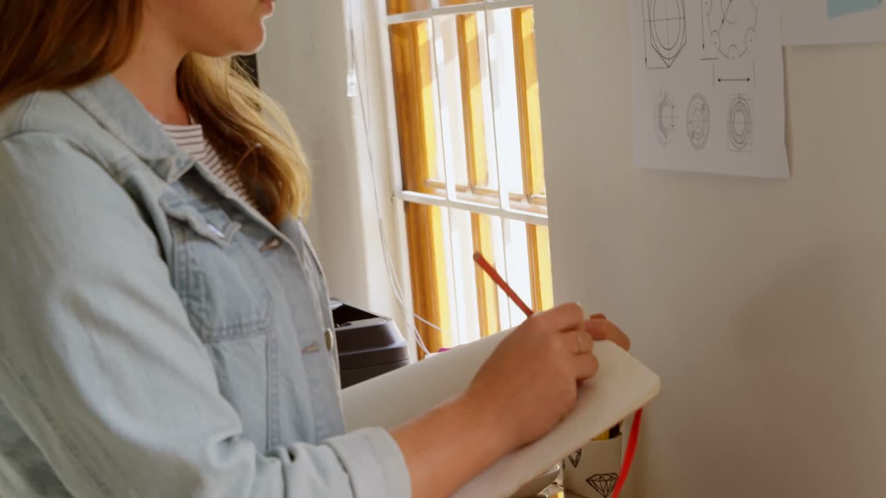 diseñadora de joyas dibujando un boceto en papel blanco 4k