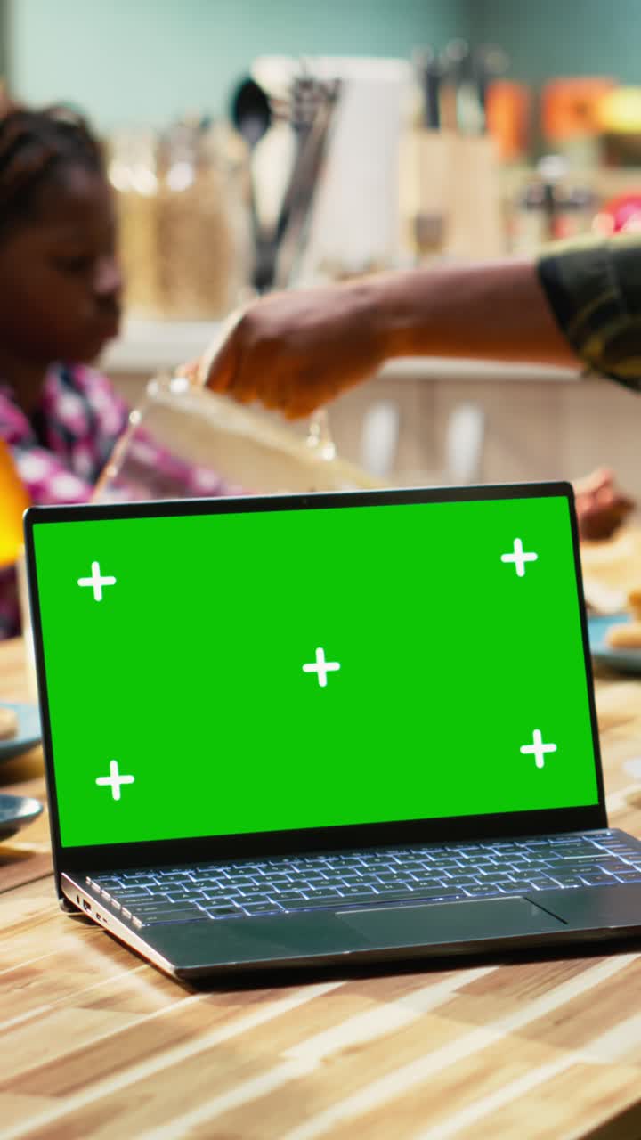Vertical Video Green screen next to parents and children sharing breakfast in home kitchen