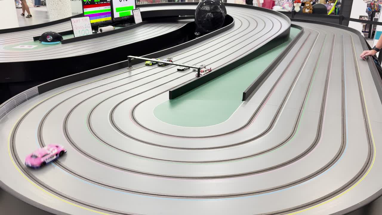 미니어처 자동차가 휘어지는 트랙에서 경주하고 있습니다.