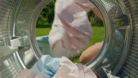 loading clothes into a washing machine in a garden