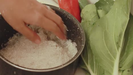 measuring the water level for cooking rice using the fingers, traditional filipino way showing a candid glimpse of daily life at home in the philippines