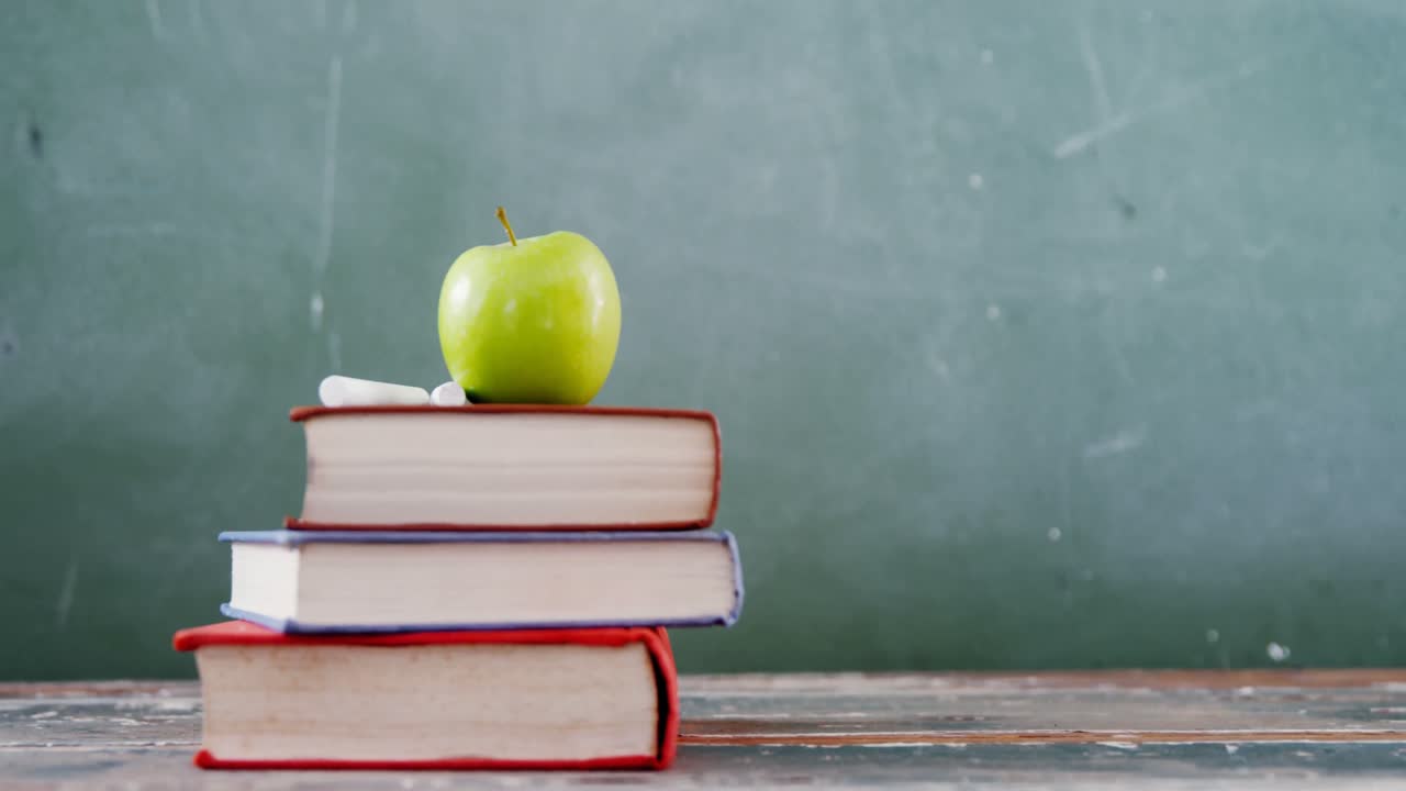 manzana y tiza en la pila de libros