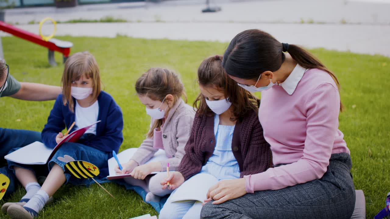 코로나19 격리 및 봉쇄 이후 학교에서 야외에서 배우는 즐거운 아이들의 그룹.