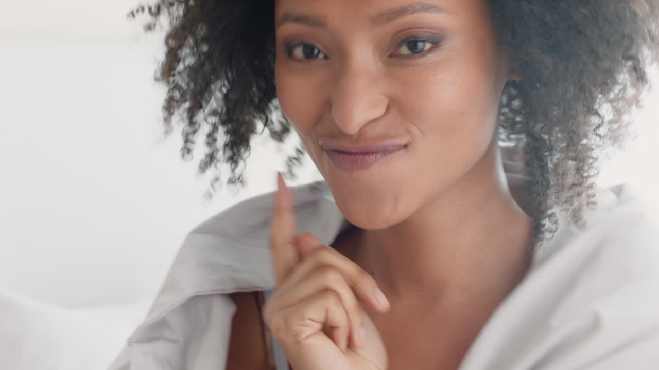 hermosa mujer jugando en la cama escondiéndose bajo una manta divirtiéndose disfrutando de una mañana lúdica en casa