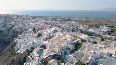 soar above the captivating white architecture of fira, santorini, set against the deep blue aegean sea