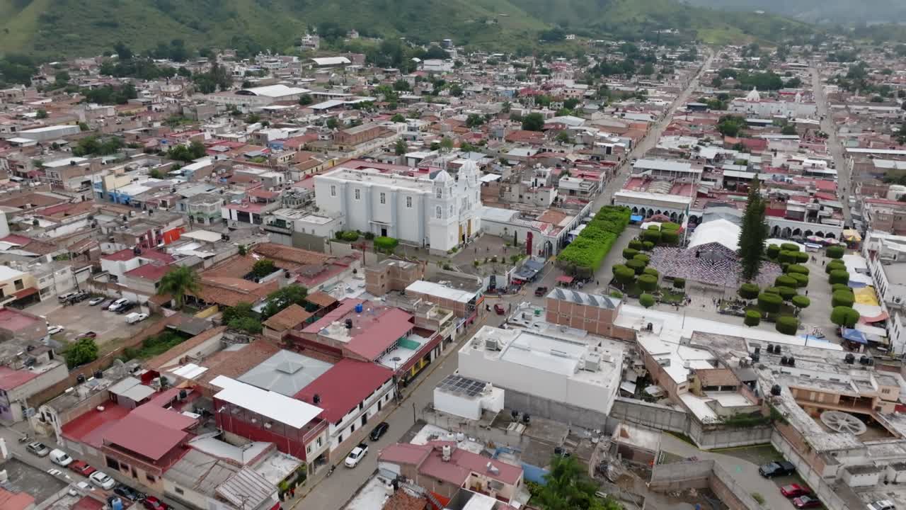 tomada aérea de la ciudad antigua de tecalitlan con techos rústicos y catedral durante el día en méxico