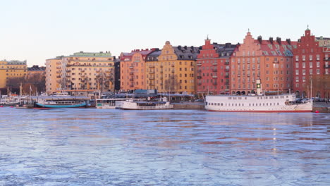 Unique-architecture-of-buildings-on-waterfront-and-moored-boats,-Riddarfjarden