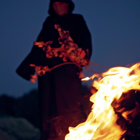 scary witch conjures around the fire. a terrible ritual. halloween. horror.
