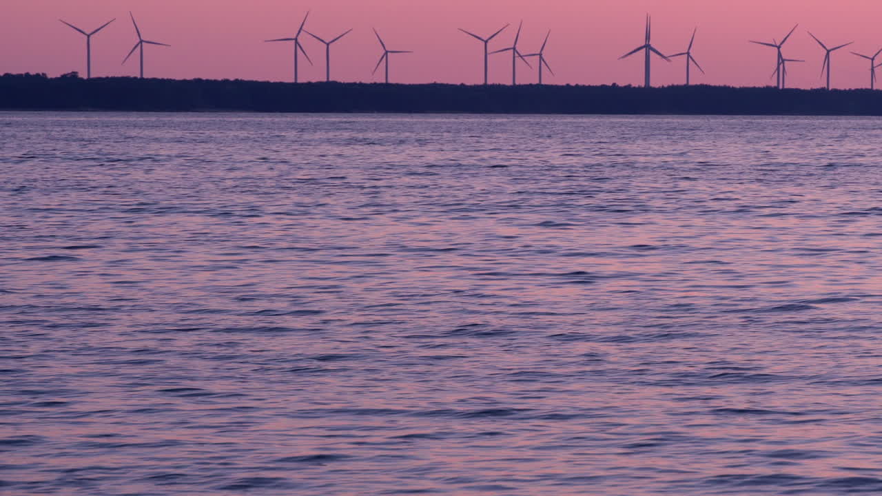 핑크색 일몰에 회전하는 풍력 터빈