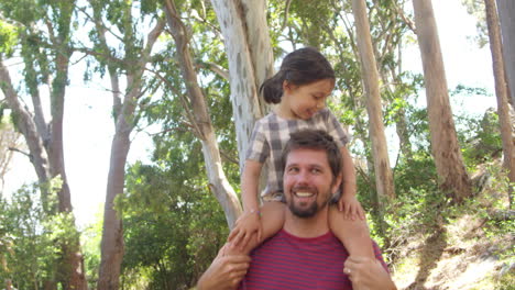 Daughter-Riding-On-Father's-Shoulders-On-Countryside-Walk