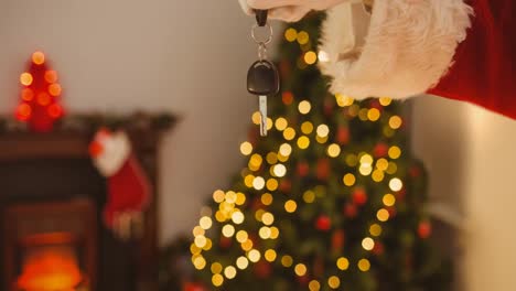 Animation-of-hand-of-santa-claus-holding-car-keys-over-blurred-background-with-christmas-decorations