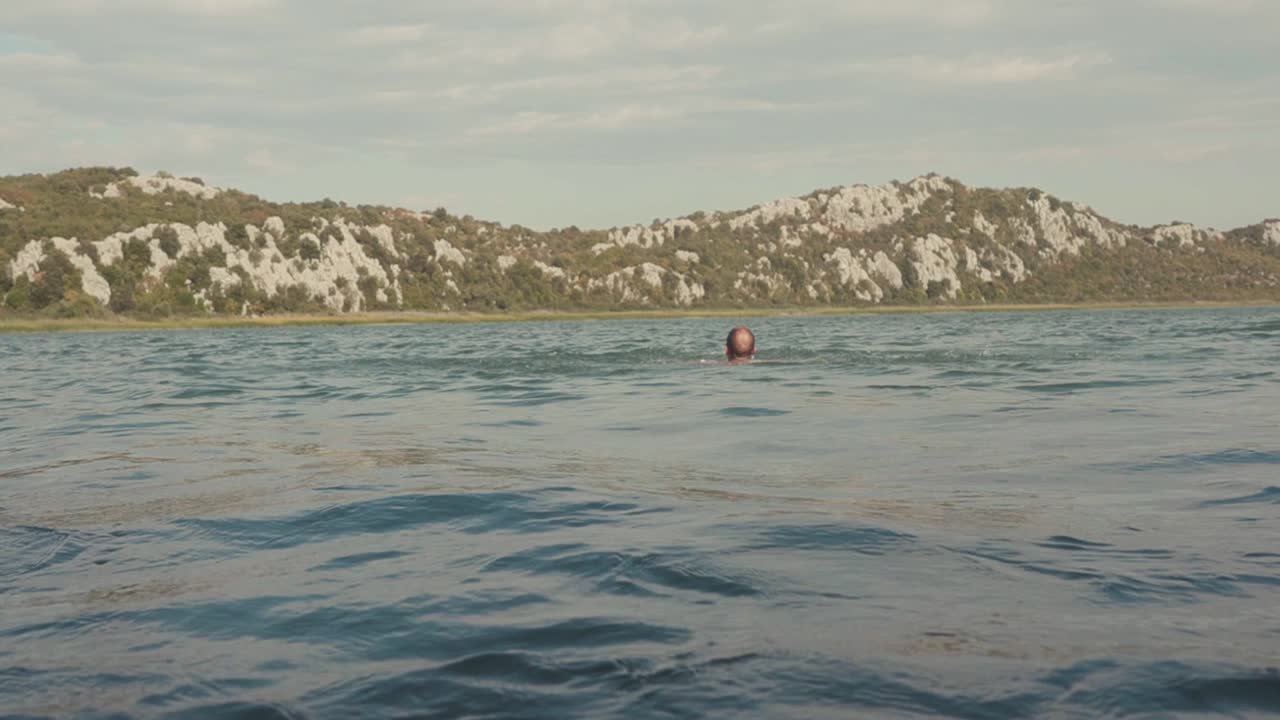hombre nadando en un lago de montaña