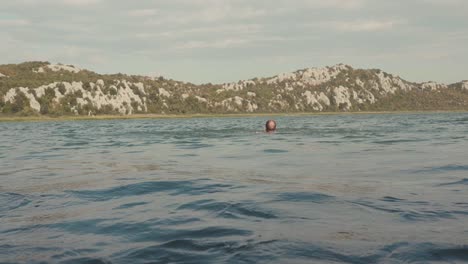 man swimming in a mountain lake