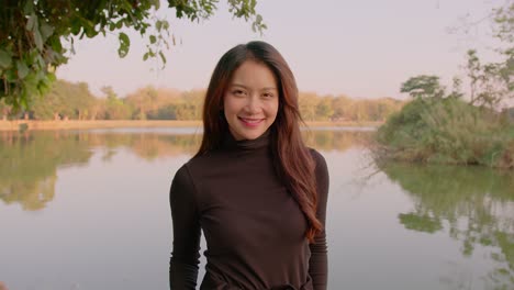 woman smiling in a park by a lake
