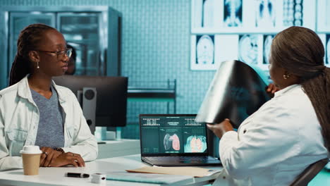 black patient interacting with a female physician in a medical cabinet