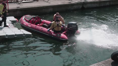 two young dublin fire brigade men, first responders, launching an inflatable rescue boat, slow motion