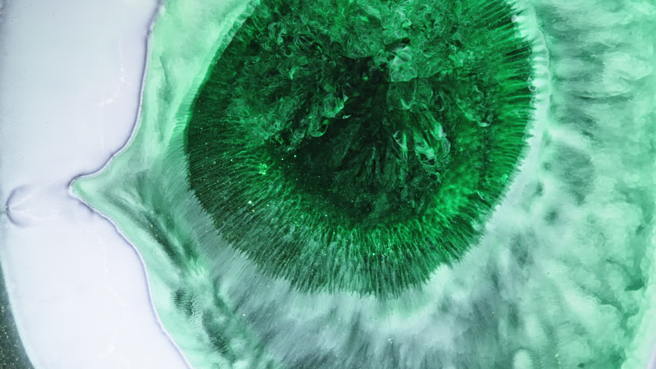 Encre verte tourbillonnante, plan macro, évoque une ambiance calme et créative.