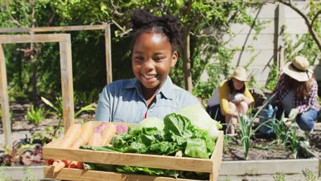 Retrato-De-Una-Feliz-Niña-Afroamericana-Haciendo-Jardinería,-Mirando-La-Cámara-Y-Sonriendo