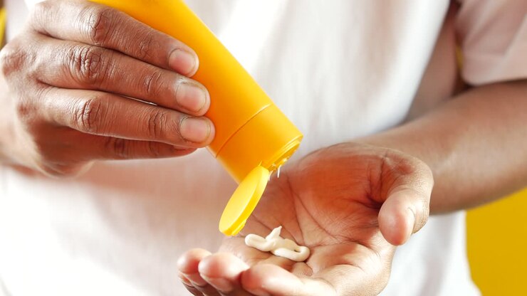 Young men using sun screen close up